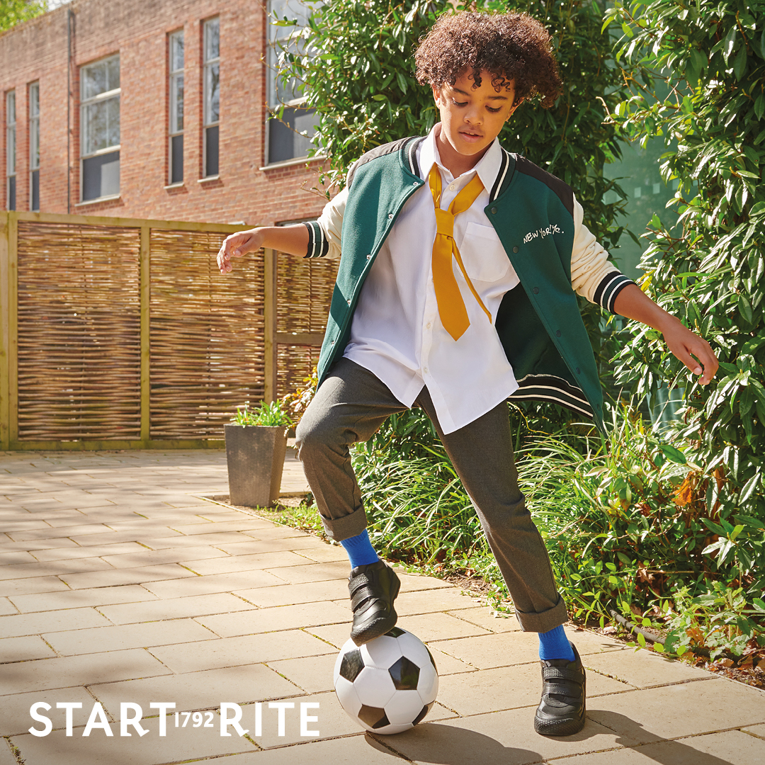 School boy in the playground playing football wearing Start-Rite Rhino school shoes